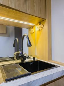 a kitchen with a sink and two faucets at Cozy Jogja in Yogyakarta