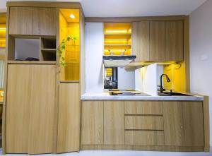 a kitchen with wooden cabinets and a sink at Cozy Jogja in Yogyakarta +14 photos
