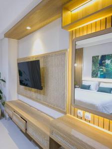 a room with a tv and a bed and a mirror at Cozy Jogja in Kejayan