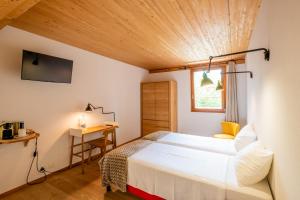 a bedroom with a bed and a desk and a window at La Ferme du Lignon in Geneva