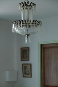 a clear glass chandelier hanging from a ceiling at les chambres fleuries in Saint-Benoît-du-Sault