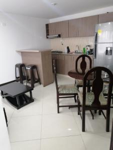 cocina con mesa, sillas y nevera en Moderno apartamento para huespedes en Ipiales