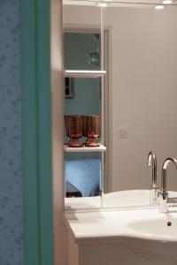 y baño con lavabo y espejo. en les chambres fleuries, en Saint-Benoît-du-Sault