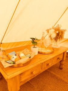 una mesa de madera con dos platos de comida. en Fen meadows glamping - Luxury cabins and Bell tents en Cambridge