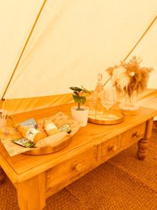 a wooden table with two plates of food on it at Fen meadows glamping - Luxury cabins and Bell tents in Cambridge