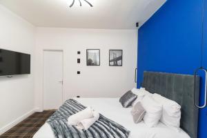 a bedroom with a bed with a blue accent wall at Spencer House in Leeds