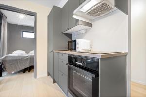 een kleine keuken met een magnetron en een fornuis bij Forenom Serviced Apartments Oslo Munch in Oslo