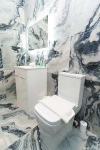 uma casa de banho com um WC branco e um lavatório. em Spencer House em Leeds