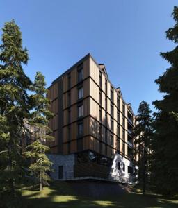 a large building with trees in front of it at Woodside Apartment in Kopaonik