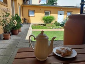 a tea kettle and a plate of pastries on a table at Apartmán Maya in Pardubice