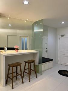 a large kitchen with two stools and a large mirror at Riverbank Suites 805 in Kuching