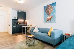 a living room with a blue couch and a kitchen at City - Travel & Living - Appartement in Bielefeld