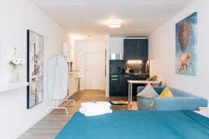 a living room with a blue couch and a kitchen at City - Travel & Living - Appartement in Bielefeld