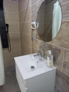 La salle de bains est pourvue d'un lavabo blanc et d'un miroir. dans l'établissement La grenadine, à Sainte-Anne-les Hauts