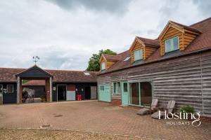 a horse is standing in the courtyard of a house at Foxglove Barn - Rurally located 3 bed equestrian paradise in Aylesbury