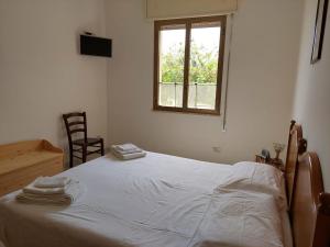 a bedroom with a large white bed with a window at Rocca tagliata Marsala in Marsala