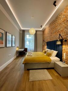 a bedroom with a large bed and a brick wall at Golden Queen Apartments City Center in Krakow