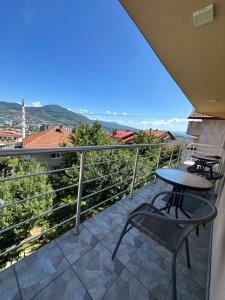 a balcony with tables and chairs and a view at Apartman Ejna in Sarajevo