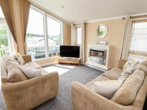 a living room with two couches and a television at 15 Silverbirch in Morpeth