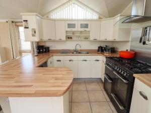 a kitchen with white cabinets and a stove top oven at 15 Silverbirch in Morpeth