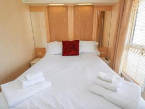 een bed in een kamer met handdoeken bij 15 Silverbirch in Morpeth
