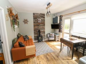 a living room with a couch and a table at The Donkey Den in Sidmouth