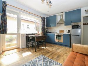 a kitchen with blue cabinets and a table in a room at The Donkey Den in Sidmouth
