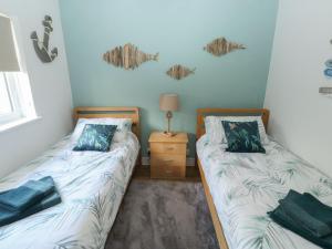 a bedroom with two beds and a night stand with a lamp at The Donkey Den in Sidmouth