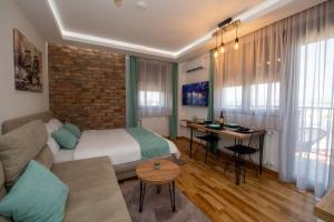 1 dormitorio con 1 cama y escritorio en una habitación en Lux Apartman Kovačević, en Jagodina
