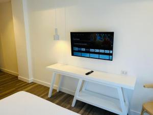 una scrivania bianca con TV a parete di Hotel dei Congressi a Castellammare di Stabia
