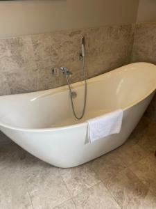 a bath tub in a bathroom with a shower at Private Guest Suite in Georgian Townhouse in City Centre in Edinburgh