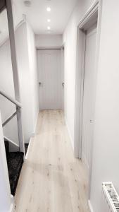 an empty hallway with white walls and wood floors at Luxurious home in Pitsea