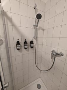 La salle de bains est pourvue d'une douche avec 2 bouteilles murales. dans l'établissement Wohnung in Hallischer Innenstadt, à Halle-sur-Saale