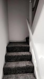 Una escalera en una casa en blanco y negro en Luxurious home, en Pitsea