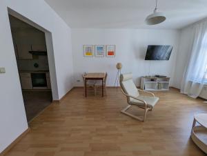 - un salon avec une table, des chaises et une télévision dans l'établissement Wohnung in Hallischer Innenstadt, à Halle-sur-Saale