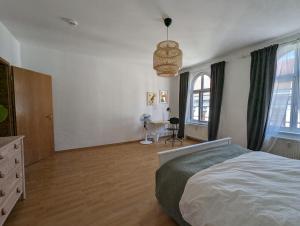 - une chambre avec un lit, un bureau et des fenêtres dans l'établissement Wohnung in Hallischer Innenstadt, à Halle-sur-Saale