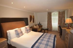 a hotel room with a bed and a desk and a room at Durrant House Hotel in Bideford