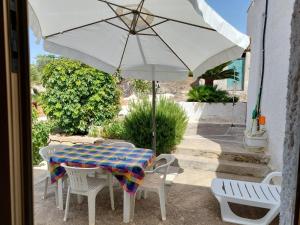 a table and chairs with an umbrella on a patio at Rocca tagliata Marsala in Marsala