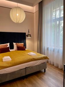 1 dormitorio con 1 cama grande y ventana grande en Golden Queen Apartments City Center en Cracovia