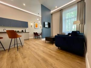 a living room with a blue couch and a kitchen at Golden Queen Apartments City Center in Krakow