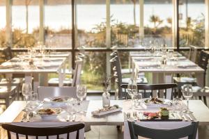 a dining room with tables with plates of food at Falkensteiner Hotel Park Punat in Punat