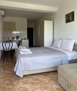 a bedroom with a large bed and a kitchen at Apartmani Neda Bane in Petrovac na Moru