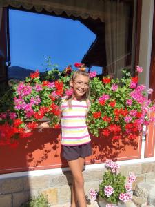 コプリフシティツァにあるРадкината къщаの花の前に立つ少女