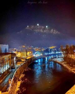 un pont sur une rivière dans une ville la nuit dans l'établissement Borjomi Classic Hotel, à Bordjomi
