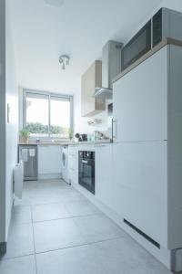 uma cozinha com electrodomésticos brancos e uma grande janela em Logement équipé em Saint-Paul-de-Varax