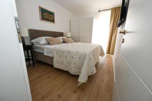 - une chambre avec un lit et du parquet dans l'établissement Apartman Zrno Soli, à Zadar