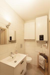 uma casa de banho branca com um lavatório e um WC em Logement équipé em Saint-Paul-de-Varax
