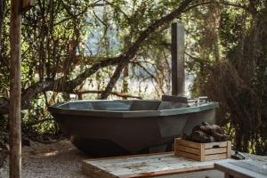 a bath tub sitting on a table in the woods at Thunzi Bush Lodge in Beach View