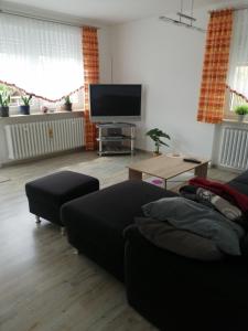 a living room with a couch and a flat screen tv at Ruhige Ferienwohnung am Waldrand. in Wildflecken
