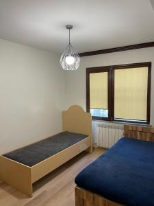 a bedroom with two beds and a pendant light at Shavishvili Guest House in Siskala